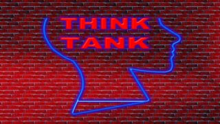 رسم لسليويت رأس إنسان بخطوط زرقاء مضيئة على حائط طوب أحمر، مكتوب بداخله "THINK TANK".