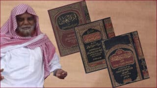 رجل بزي سعودي تقليدي مع كتب دينية بأغلفة سوداء ونقوش ذهبية.