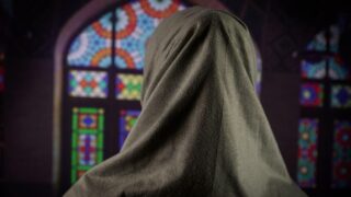 Woman praying facing the window