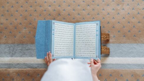 A woman reading the pages of Quran