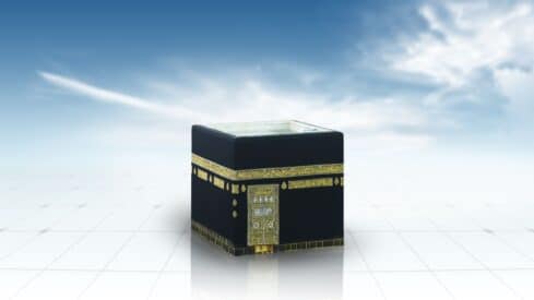 Digital depiction of the Kaaba, a black cube with gold calligraphy against a blue sky.