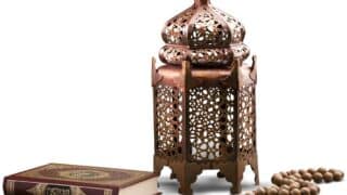 Decorative lantern with intricate metalwork, religious book, and prayer beads.