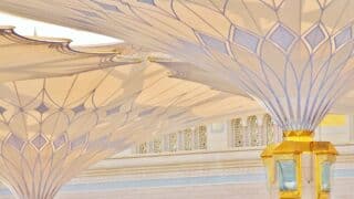 Architectural design of white umbrellas with gold geometric ornaments.