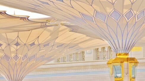 Architectural design of white umbrellas with gold geometric ornaments.