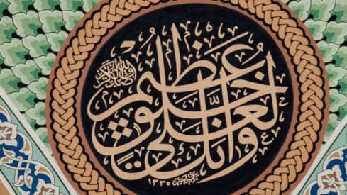 wise leader Arabic calligraphy with gold script on black, woven border, green and blue decorative motifs.