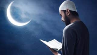 Man in a knit cap reading Quran under a crescent moon and starry night sky.