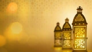 Three ornate lanterns with floral designs emit a warm, golden glow on a blurred background.