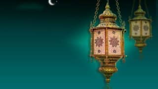 Ornate lantern with intricate patterns, golden details against teal, crescent moon above.