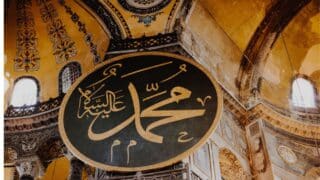 Large decorative panel with Arabic calligraphy Mohamed in a historic ornate building interior.