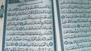 Two pages of quran with ornate blue borders from a religious manuscript.