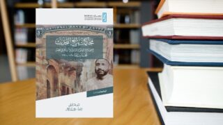 كتاب "الإضاءة على الحقائق المجهولة" على طاولة مكتبة بجانب كومة كتب.